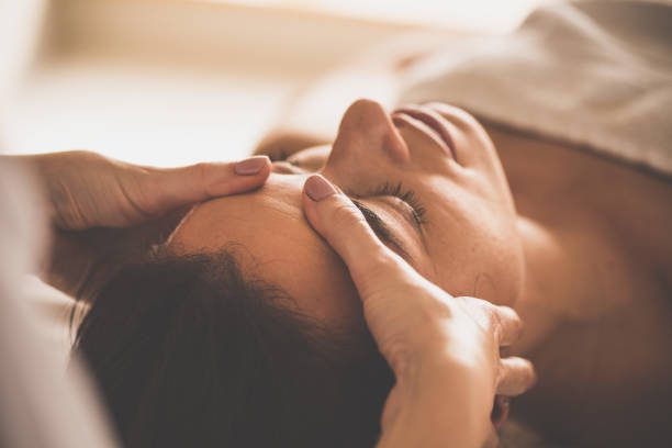 femme recevant un massage du visage au spa - réflexologie photos et images de collection
